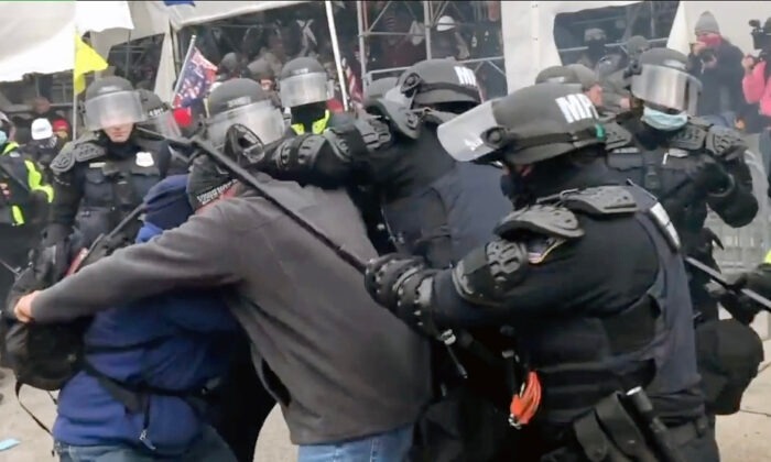 La policía ataca a dos manifestantes en el lado oeste del Capitolio el 6 de enero de 2021, en esta escena del documental de EpochTV, "La verdadera historia del 6 de enero". (Steve Baker/Para EpochTV)