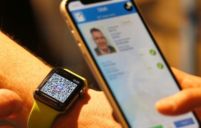 Una persona escanea un código QR en un Apple Watch para enviar temporalmente su licencia de conducir digital a otro teléfono móvil en una tienda de comestibles Harmons, en Salt Lake City, Utah, el 4 de agosto de 2021. (George Frey/Getty Images)