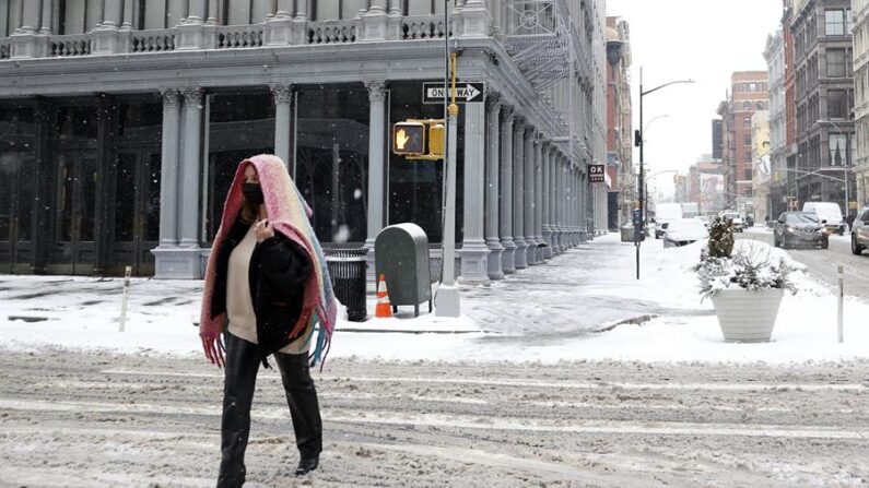 Una persona camina por una calle de Nueva York cubierta por la nieve, en una fotografía de archivo. EFE/ Jason Szenes