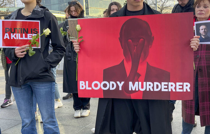 Un grupo de personas protestan frente a la sede europea de las Naciones Unidas en Ginebra para homenajear al líder opositor ruso Alexéi Navalni, pocas horas después de conocerse su fallecimiento en prisión. (EFE/Anisia Gil)