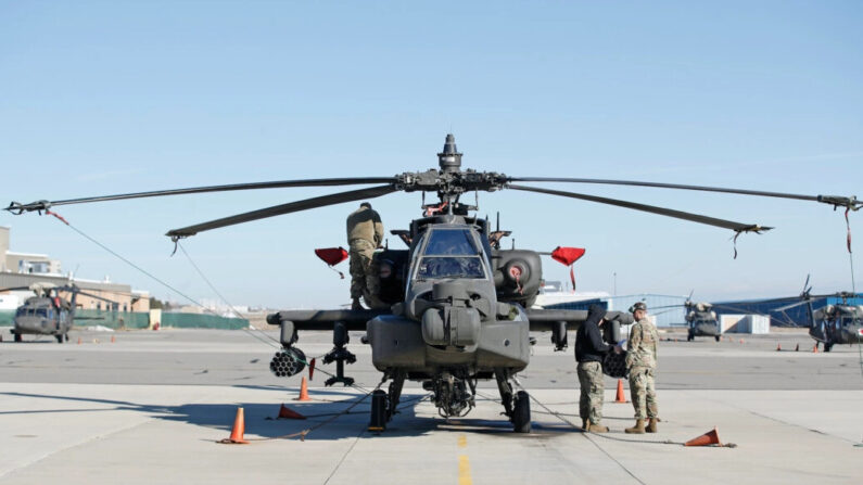 Trabajadores de mantenimiento inspeccionan un helicóptero AH-64 Apache en Kearns, Utah, el 4 de marzo de 2020. (George Frey/Getty Images)
