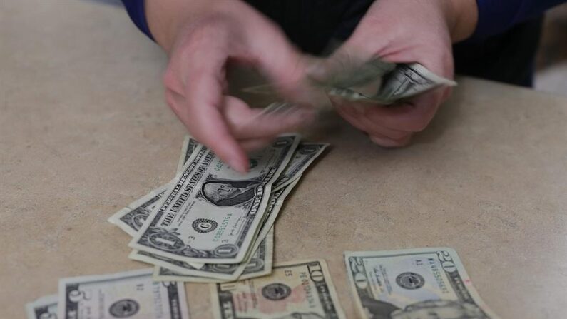 Una persona cuenta dolares en una casa de cambio hoy, en ciudad Juárez, en el estado de Chihuahua (México). EFE/ Luis Torres