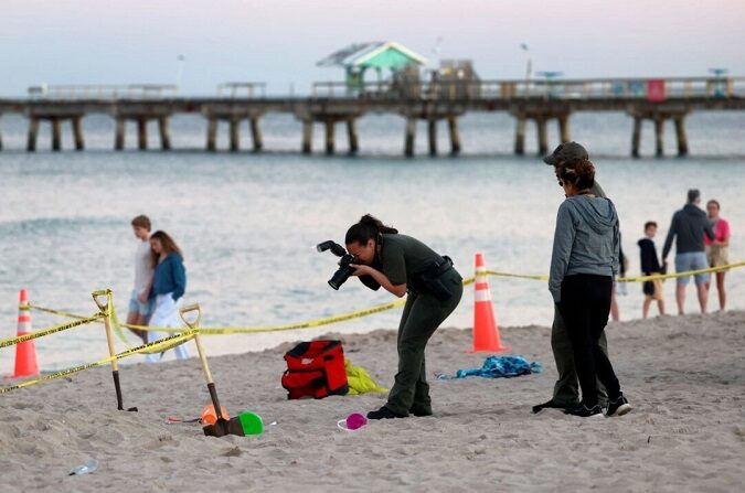 Investigadores en la playa de Lauderdale-by-the-Sea, Florida, toman fotos de la escena de un derrumbe de arena el 20 de febrero de 2024. (Mike Stocker/South Florida Sun-Sentinel vía AP)