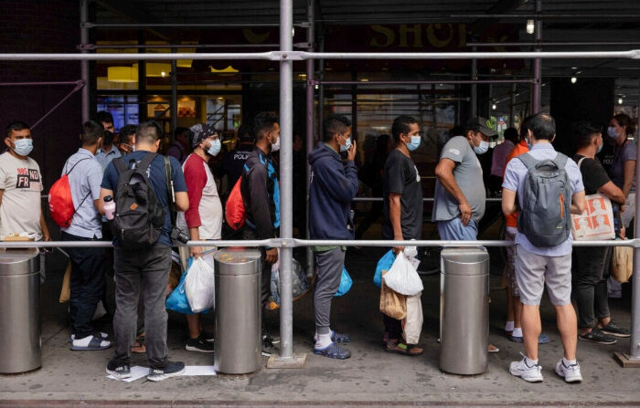 Un grupo de migrantes de Texas hace fila frente a la terminal de autobuses Port Authority para recibir ayuda humanitaria el 10 de agosto de 2022 en Nueva York. - Texas ha enviado a miles de migrantes del estado fronterizo a Washington, DC, Nueva York y otras zonas. (YUKI IWAMURA/AFP vía Getty Images)