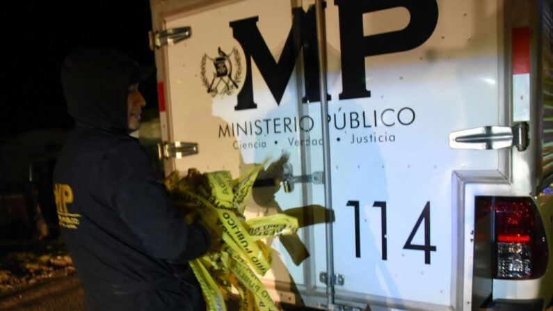 Un oficial forense maneja la cinta de acordonamiento en la escena de un accidente en Guatemala el 28 de marzo de 2019. (Johan Ordonez/AFP vía Getty Images)