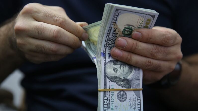 Un hombre cuenta un montón de billetes de banco en dólares estadounidenses en Bagdad, la capital iraquí, el 4 de mayo de 2020, (AHMAD AL-RUBAYE/AFP vía Getty Images)