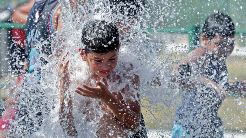 Niños se refrescan en un juego de agua en el Parque de los Niños, en Buenos Aires (Argentina), el 13 de enero de 2022. (Alejandro Pagni/AFP vía Getty Images)