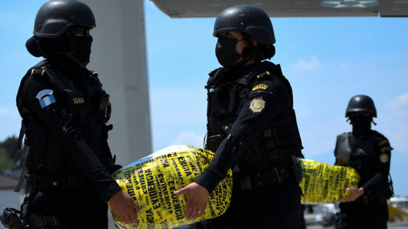 Agentes de policía transportan paquetes de cocaína incautada a su llegada a la base de la Fuerza Aérea en Ciudad de Guatemala (Guatemala) el 4 de abril de 2022. (Johan Ordonez/AFP vía Getty Images)