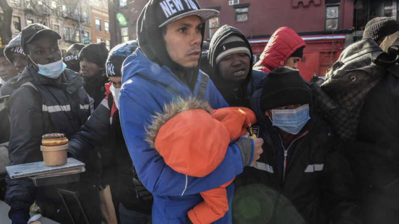 Migrantes sin hogar esperan en fila para recibir donaciones de alimentos y ropa en Tompkins Square Park el 20 de enero de 2024 en la ciudad de Nueva York. (Stephanie Keith/Getty Images)