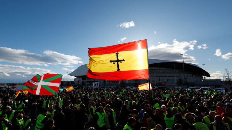 Manifestantes ondean una bandera de la región vasca de Ikurrina y una bandera española mientras se reúnen durante una protesta de agricultores contra la fuerte regulación y las importaciones más baratas, frente al estadio Metropolitano de Madrid (España) el 10 de febrero de 2024. (Oscar Del Pozo/AFP vía Getty Images)