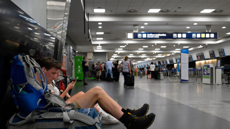Un hombre se sienta en el suelo junto a su equipaje durante una huelga aeronáutica en el aeropuerto Jorge Newbery de Buenos Aires (Argentina) el 28 de febrero de 2024. (Juan Mabromata/AFP vía Getty Images)