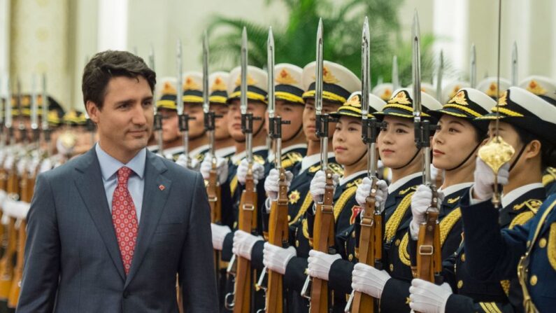 El primer ministro de Canadá, Justin Trudeau, camina durante una revisión de los guardias paramilitares chinos con el primer ministro de China, Li Keqiang, durante una ceremonia de bienvenida en el Gran Salón del Pueblo en Beijing el 4 de diciembre de 2017. (Fred Dufour/AFP vía Getty Images)