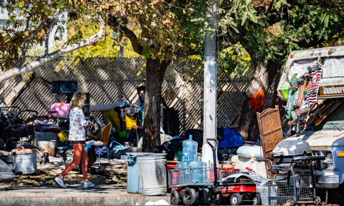 Una mujer pasa por delante de un campamento de personas sin hogar en el barrio de Venice, en Los Ángeles, el 18 de febrero de 2022. (John Fredricks/The Epoch Times)