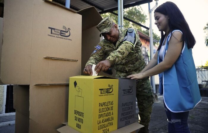 Un militar ayuda a una jurado de votación a sellar una urna en el Teatro de Cámara en San Salvador, El Salvador. (EFE/ Rodrigo Sura)