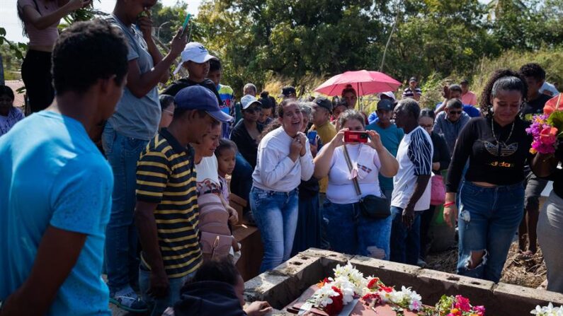 Familiares se lamentan junto al féretro de una de las víctimas mortales del derrumbe en la mina 'Bulla Loca', durante su entierro este jueves, en La Paragua (Venezuela). EFE/ Rayner Peña R