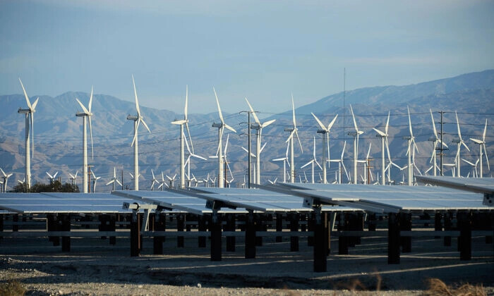 Turbinas eólicas gigantes son impulsadas por fuertes vientos frente a paneles solares en Palm Springs, California, el 27 de marzo de 2013. (Kevork Djansezian/Getty Images)