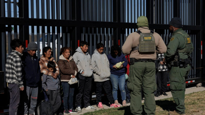 Agentes de la Patrulla Fronteriza de Estados Unidos custodian a inmigrantes ilegales que cruzaron a Shelby Park mientras esperan ser recogidos para su procesamiento, en Eagle Pass, Texas, el 4 de febrero de 2024. (Michael Gonzalez/Getty Images)
