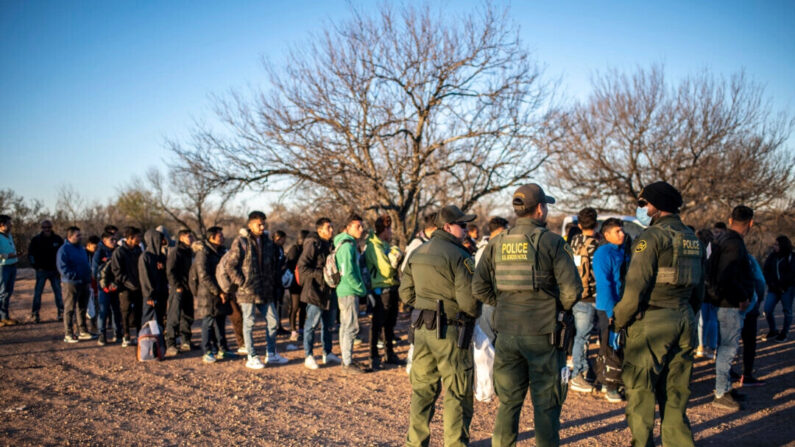 Un grupo de inmigrantes ilegales son procesados ​​por la Patrulla Fronteriza después de cruzar el río cerca de la carretera en las afueras de Eagle Pass, Texas, el 4 de febrero de 2024. (Sergio Flores/AFP/Getty Images)