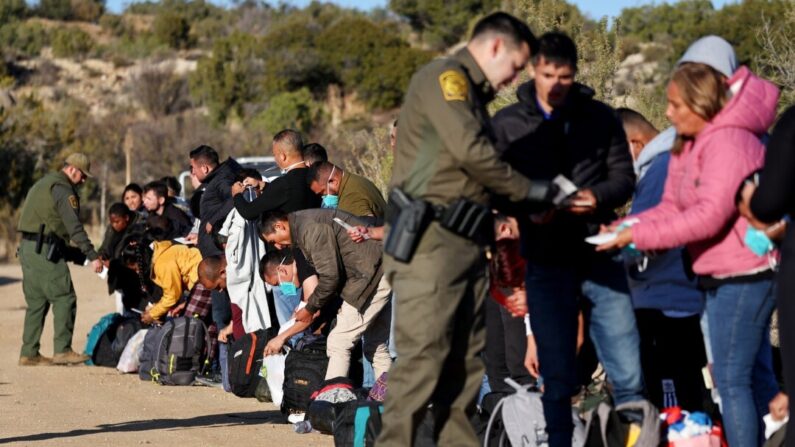 Agentes de la Patrulla Fronteriza de Estados Unidos revisan los documentos de identificación de inmigrantes ilegales antes de ser transportados a un centro de procesamiento de la Patrulla Fronteriza en Jacumba Hot Springs, California, el 1 de diciembre de 2023. (Mario Tama/Getty Images)