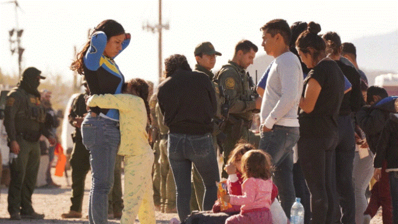 Extranjeros ilegales esperan fuera de una estación de procesamiento cerca del Puerto de Entrada de Lukeville, en el sur de Arizona, el 7 de diciembre de 2023. (Allan Stein/The Epoch Times)