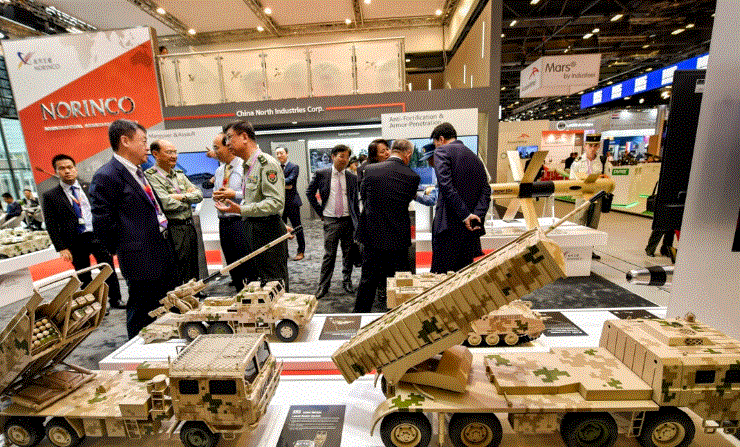 Visitantes hablan con personal militar junto a modelos de vehículos militares fabricados por una empresa china en una exposición internacional en Villepinte, cerca de París, el 11 de junio de 2018. (Gerard Julien/AFP vía Getty Images)