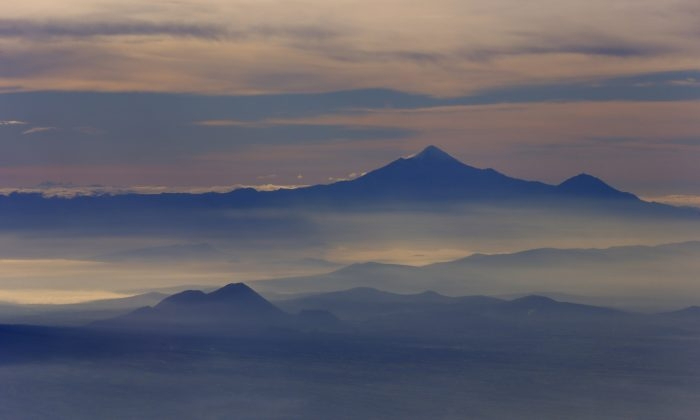 El pico más alto de México y el tercero más alto de América del Norte, el Pico de Orizaba, o Citlaltepetl, se eleva por encima de la niebla de la mañana como se ve desde un avión de la Marina mexicana en una misión de vigilancia del volcán en México el 23 de julio de 2013. (Darío López-Mills/Foto AP)