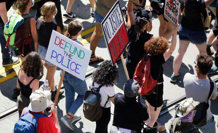 La gente lleva carteles durante una marcha para "desfinanciar a la policía" en Seattle, Washington, el 5 de agosto de 2020. (Jason Redmond/AFP/Getty Images)