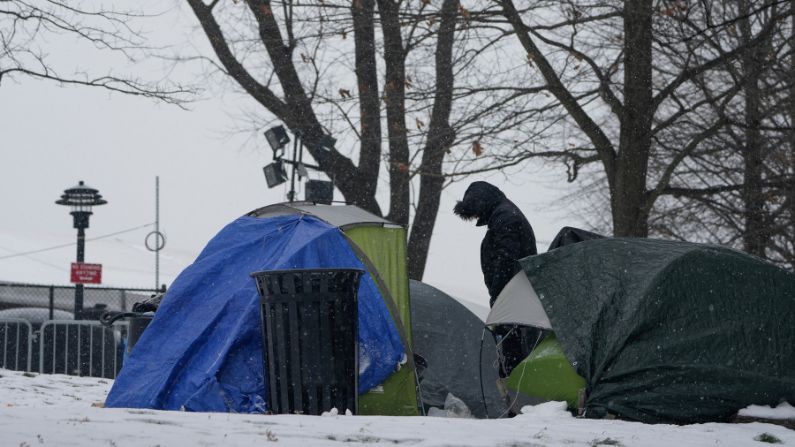 Un hombre se encuentra cerca de un grupo de pequeñas tiendas de campaña instaladas cerca de un refugio temporal para inmigrantes en Randall's Island en Nueva York, el viernes 19 de enero de 2024. (AP/Seth Wenig)