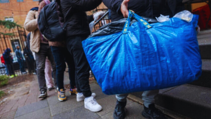 Un inmigrante recién llegado lleva sus pertenencias mientras recibe una merienda de Trinity Services and Food For the Homeless, frente a Tomkins Square Park, en Nueva York, el 24 de enero (Spencer Platt/Getty Images).