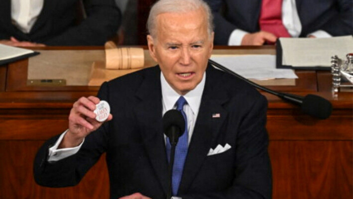 El presidente Joe Biden sostiene un botón "Say her name Laken Riley" mientras pronuncia el discurso sobre el Estado de la Unión en la Cámara de Representantes del Capitolio de EE.UU. en Washington el 7 de marzo de 2024. (Saul Loeb/AFP vía Getty Images)