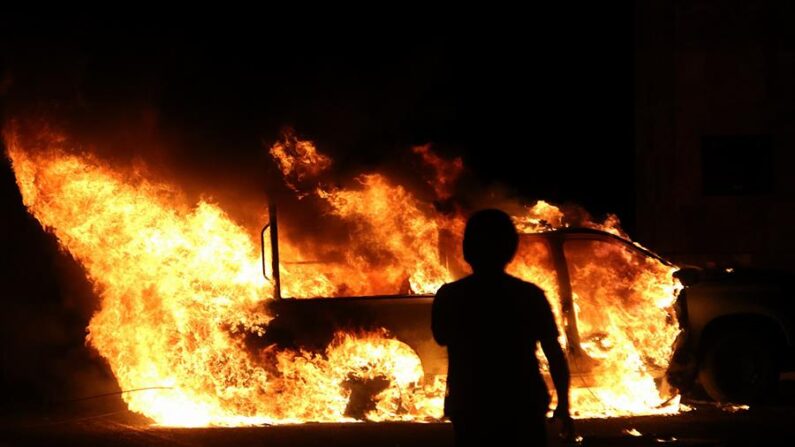Una persona observa una patrulla de la Guardia Nacional (GN) incendiada por presuntos estudiantes normalistas en municipio de Tixtla, estado de Guerrero (México), el 9 de marzo de 2024. EFE/José Luis de la Cruz