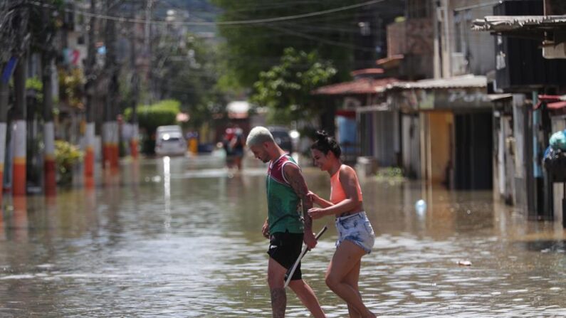 Habitantes transitan por una calle inundada tras las lluvias en el área metropolitana de Río de Janeiro (Brasil), en una fotografía de archivo. EFE/André Coelho