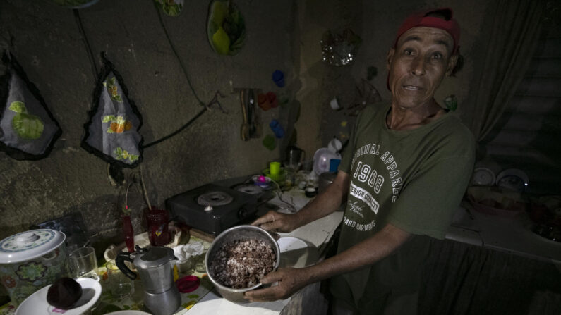 Un cubano muestra la comida estropeada por falta de frio, durante un apagón, en el poblado de Santa Marta, Varadero (Cuba) el pasado 12 de marzo. Los apagones se han exacerbado  en los últimos dos meses con la crisis energética que sufre la isla. (EFE/Yander Zamora)