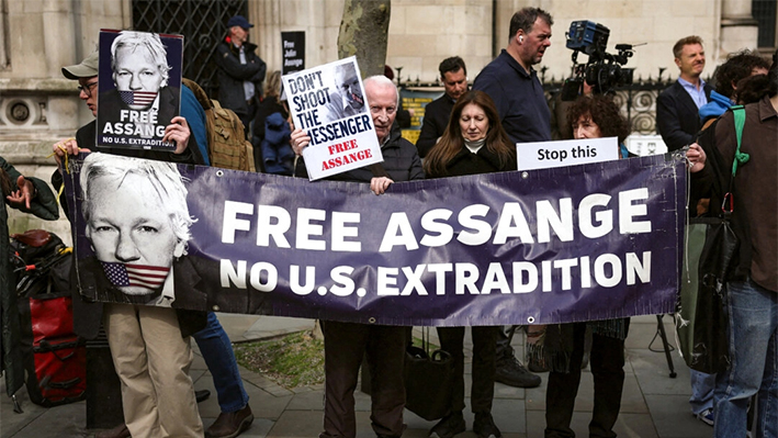 Partidarios del fundador de WikiLeaks, Julian Assange, sostienen una pancarta y pancartas ante los Tribunales Reales de Justicia, el Tribunal Supremo británico, en el centro de Londres, el 26 de marzo de 2024. (Daniel Leal/AFP vía Getty Images)
