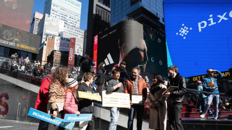 El ganador del primer lugar, Samuel Coggin (C), y su familia en la ceremonia de premios de videos "La bondad es genial" de Gan Jing World en Times Square, Nueva York, el 8 de marzo de 2024. (Foto: Larry Dye/The Epoch Times)