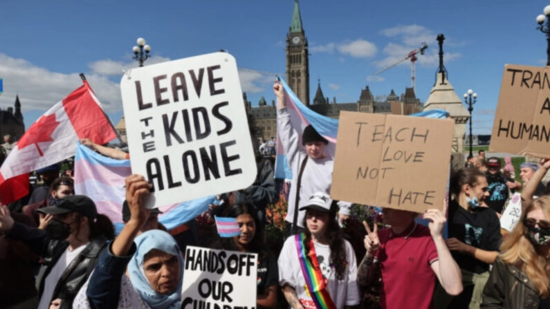 Manifestantes sostienen pancartas frente a contramanifestantes en una manifestación contra programas sobre orientación sexual e identidad de género en las escuelas, frente al Parlamento Hill en Ottawa, Canadá, el 20 de septiembre de 2023. (Patrick Doyle/The Canadian Press)