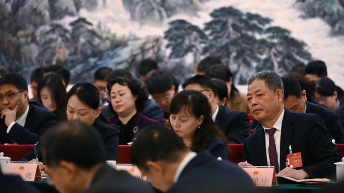 Funcionarios escuchan discursos durante la reunión de la delegación de Shaanxi en la Asamblea Popular Nacional (APN) en el Gran Salón del Pueblo en Beijing, el 6 de marzo de 2024. (GREG BAKER/AFP vía Getty Images)
