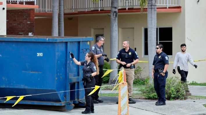 Un investigador busca huellas dactilares en un gran contenedor de basura afuera de un complejo de apartamentos en Hollywood, Florida, el 8 de enero de 2024, donde los trabajadores de la construcción encontraron un bebé muerto. (Amy Beth Bennett/Sun-Sentinel del Sur de Florida vía AP)