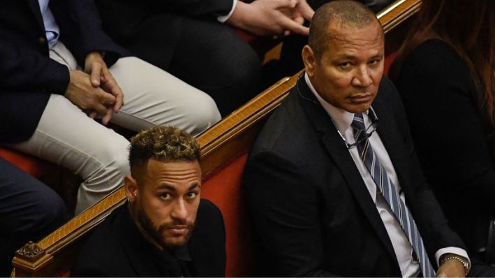 El delantero brasileño Neymar (Izq.) y su padre, el exfutbolista brasileño Neymar Santos Sr. (Der.), observan durante una audiencia en los juzgados de Barcelona en una imagen de archivo. (JOSEP LAGO/AFP vía Getty Images)