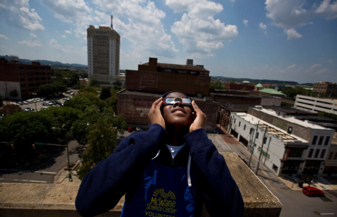 Justin Coleman, de Birmingham, Alabama, se lleva las gafas a los ojos mientras observa el eclipse solar en lo alto de un aparcamiento, en Birmingham, el 21 de agosto de 2017. (Brynn Anderson/Foto AP)
