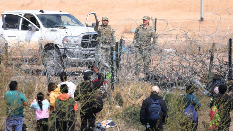 Agentes de la Guardia Nacional de Texas impiden que migrantes crucen una valla de alambre de púas en la frontera del sector de El Paso tras cruzar el río Grande desde Ciudad Juárez, estado de Chihuahua, México, el 29 de febrero de 2024. (HERIKA MARTINEZ/AFP vía Getty Images)
