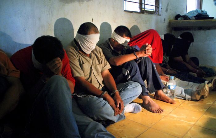 Un grupo de personas secuestradas por presuntos traficantes de drogas, se sientan en el suelo después de ser rescatados por miembros del Ejército Mexicano en Sabinas Hidalgo, a 99 km al norte de Monterrey, en el estado de Nuevo León, México, el 27 de abril de 2010. (Dario Leon/AFP via Getty Images)