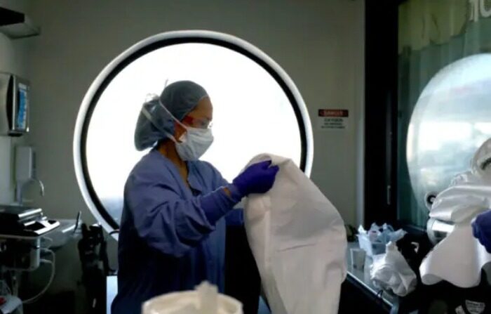 Una enfermera limpia el equipo de protección personal (EPP) después de ser parte de un equipo que realizó un procedimiento en un paciente con COVID-19 en el Centro Médico Regional en San José, California, el 21 de mayo de 2020. (Justin Sullivan/Getty Images)