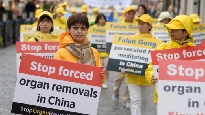 Practicantes de Falun Dafa portan pancartas para concienciar sobre la sustracción de órganos en China durante una marcha por el centro de Varsovia, Polonia, el 9 de septiembre de 2022. (Mihut Savu/The Epoch Times)
