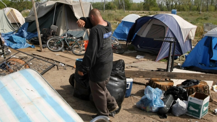 Un sin techo recoge sus pertenencias en una ciudad de tiendas de campaña en Sacramento el 13 de abril de 2009. (Justin Sullivan/Getty Images)