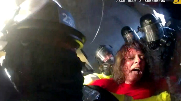 Victoria White es zarandeada y golpeada por la policía en el túnel de Lower West Terrace, en el Capitolio de Estados Unidos, el 6 de enero de 2021. (Departamento de Policía Metropolitana / Captura de pantalla vía The Epoch Times)
