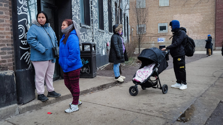 Residentes pasan tiempo juntos frente a un refugio para inmigrantes ilegales en el barrio de West Loop en Chicago, Illinois, el 30 de enero de 2024. (Scott Olson/Getty Images)
