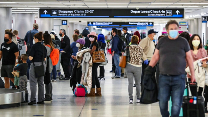 La gente recoge su equipaje después de llegar al Aeropuerto Internacional de Miami en un avión en Miami, Florida, el 1 de febrero de 2021. (Joe Raedle/Getty Images)