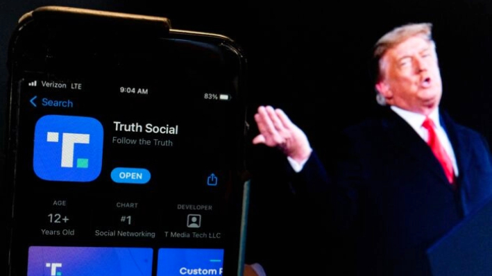 Una imagen del expresidente Donald Trump junto a la pantalla de un teléfono que muestra la aplicación Truth Social, en Washington, el 21 de febrero de 2022. (Stefani Reynolds/AFP vía Getty Images)