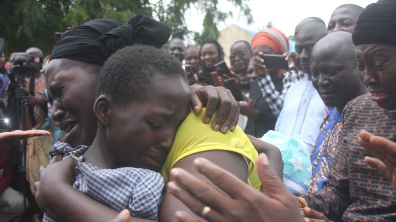 Una madre abraza a su hija después de que fuera liberada junto con otros 27 estudiantes de la Escuela Secundaria Bethel Baptist el 25 de julio de 2021. (AFP vía Getty Images)